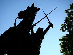 Statue of the king on the horse near the tree at beautiful blue gradient sky background in Manhattan, New York