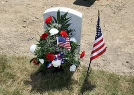 Flowers and american flags at gravestone