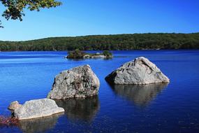 Beautiful blue lake with the stones in it among the green trees