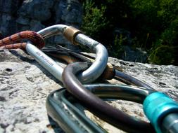 Metal Climbing Rope on the rock near the green trees