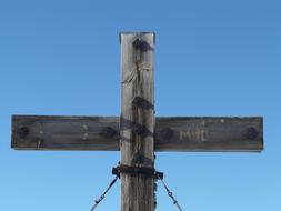 photo of a wooden cross with metal nails