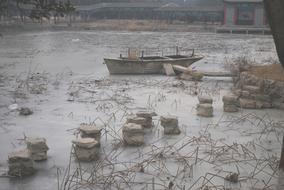 photo of a wooden boat on a frozen lake