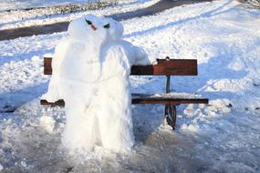 snowman sitting on the wooden bench