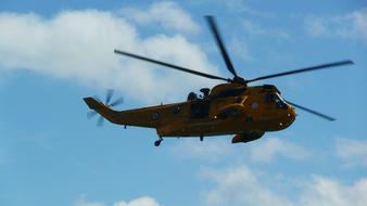 rescue yellow helicopter high in the blue sky