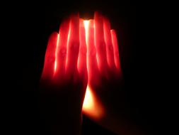 hands on a luminous lamp