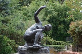 Bronze statue of the person among the colorful trees