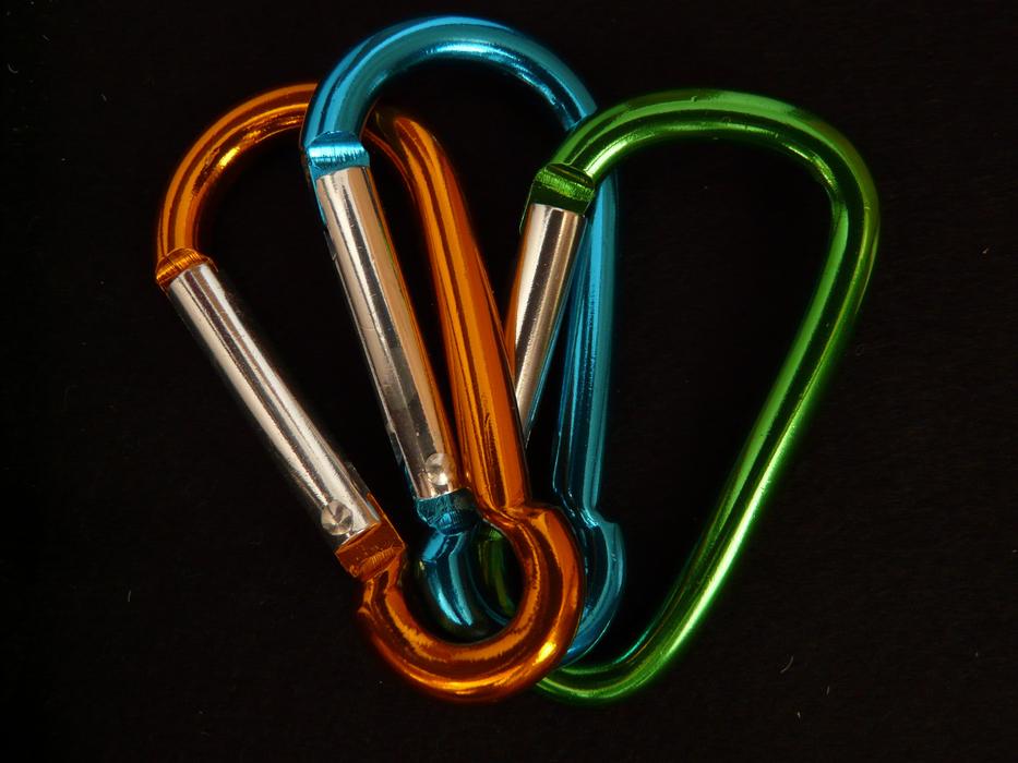 three carabiners on a black background