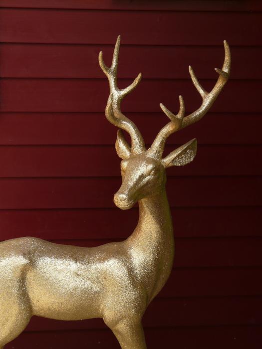 Beautiful golden stature of the deer with antlers