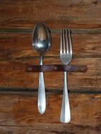 Shiny, metal spoon and fork on the wooden surface