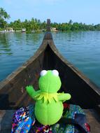 soft toy frog on a boat on the water
