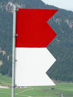 red white flag on the background of a mountain landscape