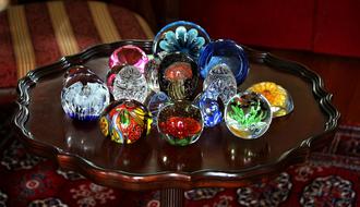 Close-up of the beautiful, colorful, shiny paperweights, on the piercrust table