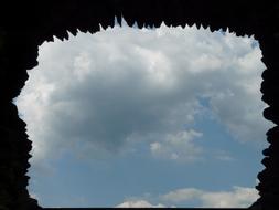 view of the sky through a stone window