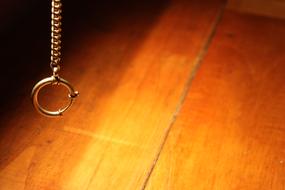 Clock Chain hanging above wooden surface