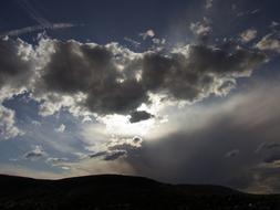 Beautiful, dark clouds in the sky, in sunlight, above the landscape