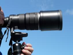 Hand on a tripod of a modern camera