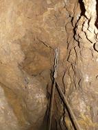 Close-up of the abseil point, with the rope, in the cave, in light and shadow