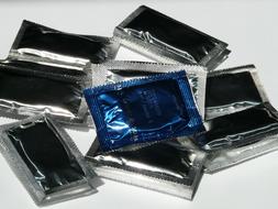 Colorful, shiny condoms on the white surface