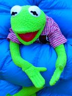 Kermit Frog toy sits on blue soft object