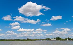 white clouds over the lake on a sunny day