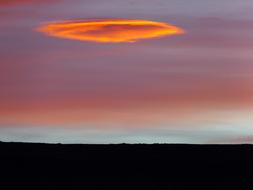 Sunrise Cloud Red over dark silhouettes