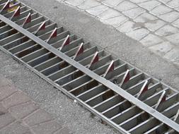 Close-up of the roadblock, with the metal teeth, on the street, in light