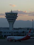 Landscape with the aircraft and tower, at the airport of Antalya, Turkey, at beautiful and colorful sunset