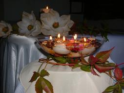 composition of burning candles floating in a vase