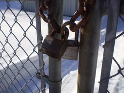 padlock on a chain on a fence