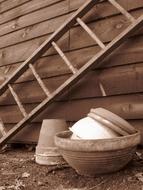 Retro photo of the pots, near the ladder on the wooden wall