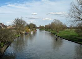 Beautiful landscape of the river, with ripple and boats, among the colorful plants, in the spring