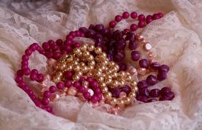Close-up of the colorful, beautiful, shiny beads with the pearls, on the patterned cloth