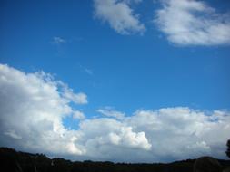 sky in white clouds over nature silhouettes