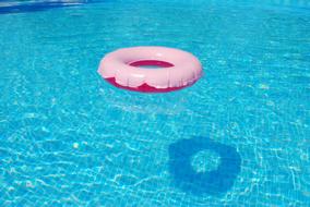 Shiny, turquoise swimming circle, in the turquoise swimming pool, with the shadow