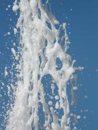 white foam fountain on blue sky background