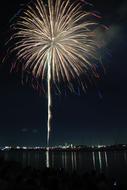 Colorful fireworks high at night sky above city at water, japan