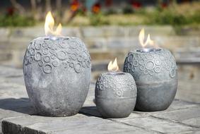 Patterned braziers with fire, near the colorful plants