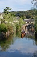 People on the colorful boat on the river in Kurashiki, Okayama, Japan, among the green plants