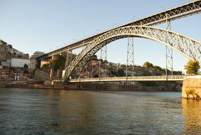 Landscape with the iron bridge, among the colorful shores with buildings, in Porto, Portugal, under the blue sky