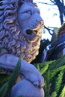 Beautiful lion statue among the plants, in the garden