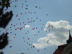 Colorful, flying balloons under the blue sky with clouds