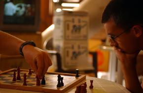 Men playing chess on the table, in the building