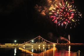 fireworks in the night sky over a bridge in florida