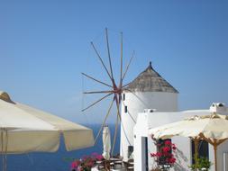 Beautiful windmill, buildings and plants on the coast of Santorini in Greece