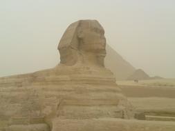 Beautiful Sphinx near the pyramid in Egypt, in dust