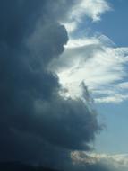 Beautiful blue sky with dark and light clouds, in sunlight