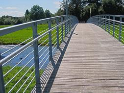 bridge with railing across the river on a sunny day