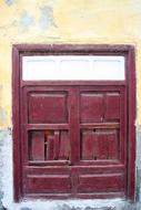 Red, wooden door in the colorful wall of the building