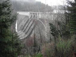 distant view of the dam in a picturesque landscape on a cloudy day