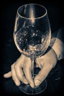 Black and white photo with the shiny, patterned wine glass in the hand